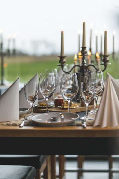 Festlich gedeckter Tisch im Wintergarten der Gastronomie Element bei Kerzenschein.