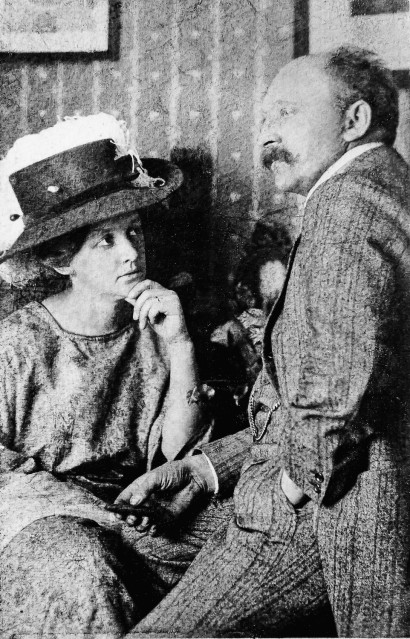 Ada Nolde sidder p&aring; en stol i kjole og stor hat, Emil Nolde sidder lidt h&oslash;jere p&aring; en skammel if&oslash;rt kjole og hvidt.