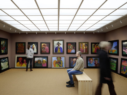 Impression aus dem Bildersaal des Nolde-Hauses mit dichter H&auml;ngung von Werken Emil Noldes und Besuchern in Bewegung.