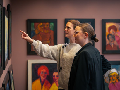 Zwei Besucherinnen betrachten ein Gem&auml;lde von Emil Nolde im Bildersaal; eine von ihnen zeigt mit ausgestreckter Hand auf das Kunstwerk.